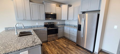 a kitchen with granite counter tops and stainless steel appliances