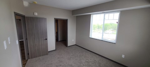 an empty living room with a window and a door
