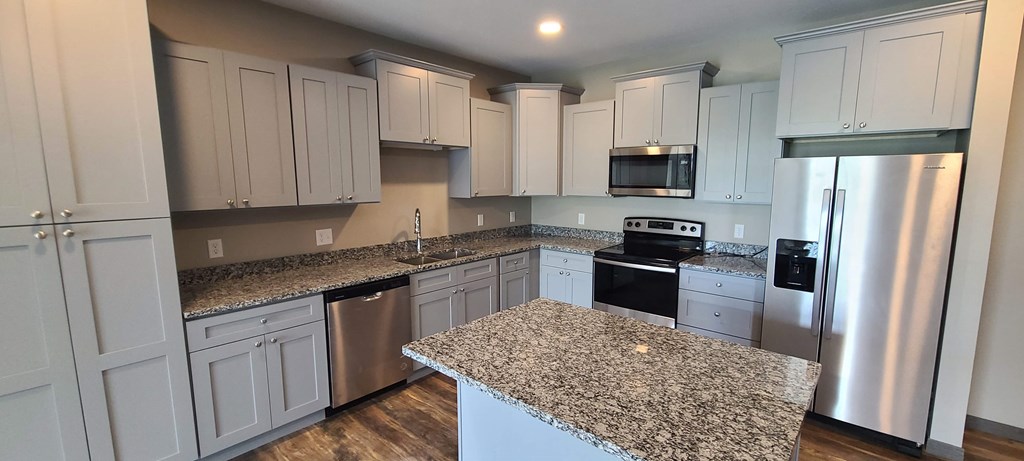 a kitchen with granite counter tops and white cabinets