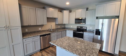 a kitchen with granite counter tops and white cabinets