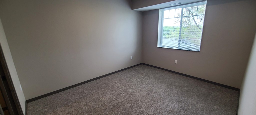 a empty room with a window and carpet