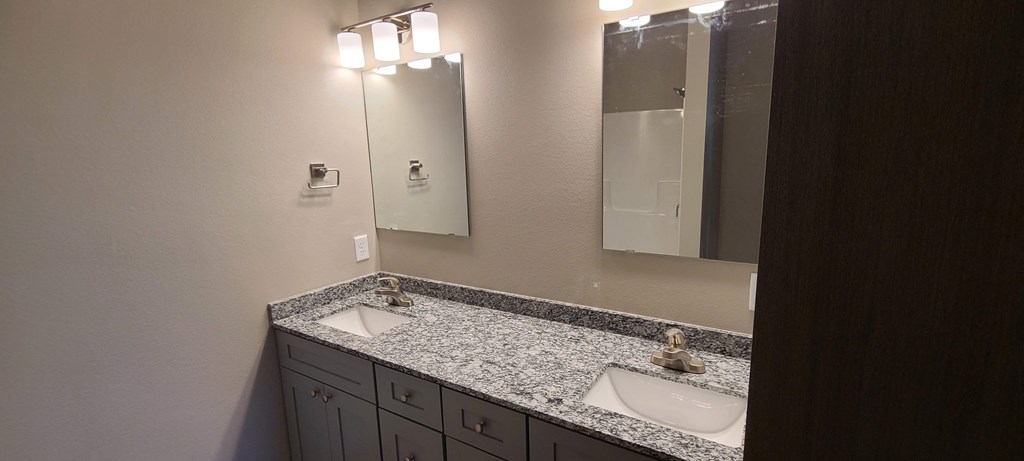 a bathroom with two sinks and a mirror