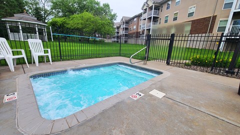 a swimming pool in a fenced in area of an apartment building