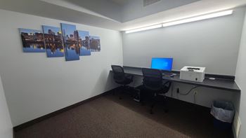 a desk with a computer and a printer in a room