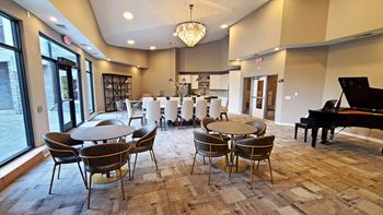 a large room with tables and chairs and a piano