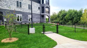 a house with a yard enclosed by a chain link fence