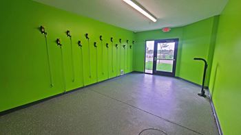 a large room with green lockers and a concrete floor