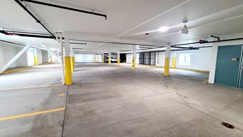 a parking garage with yellow pillars and a green door