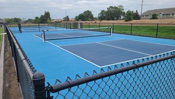 a blue tennis court with a net and a fence