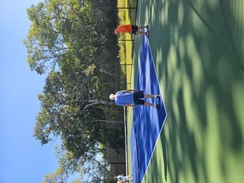 A man is climbing a rope with a blue flag attached to it.