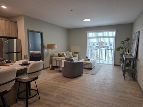 A well-lit living room with a dining table and chairs.