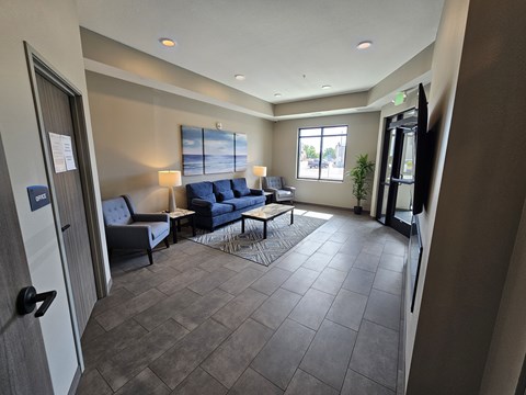 A living room with a grey couch and a blue sofa.