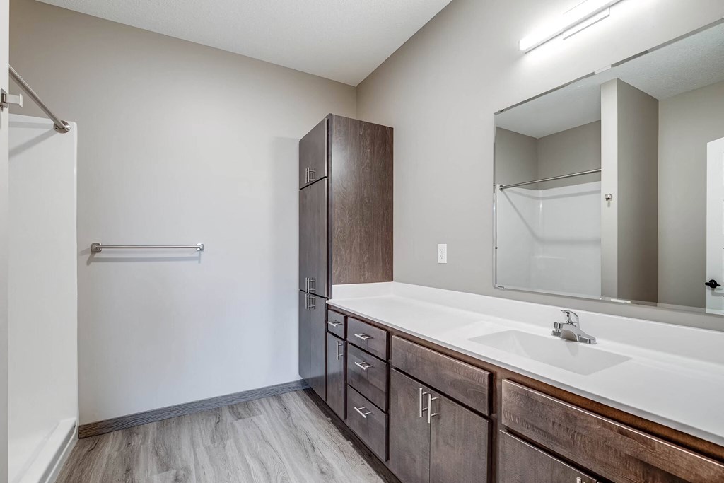 an empty bathroom with a large mirror and a sink