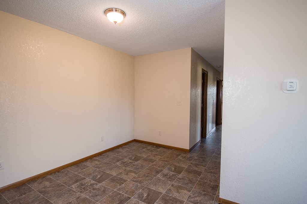 A room with a tiled floor and a doorway leading to another room.