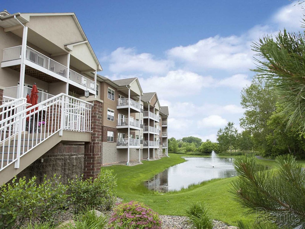 a building overlooking a pond with a fountain