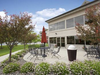 a patio with tables and chairs outside of a building