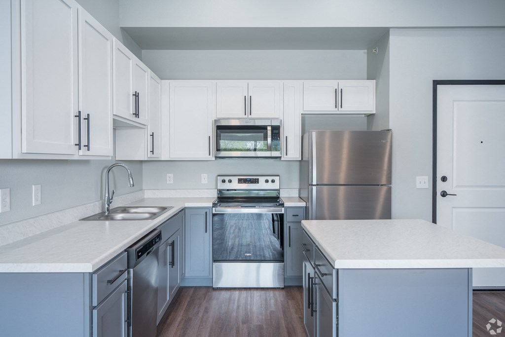 a kitchen with white cabinets and stainless steel appliances