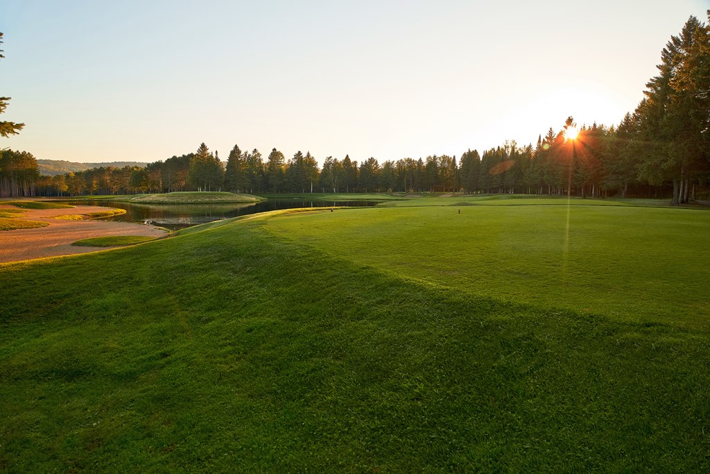 a view of a golf course with a sunset in the background