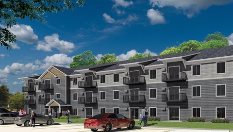 A red car is parked in front of a grey apartment building.