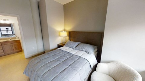 a white bed in a room with geometric wallpaper