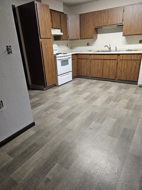 A kitchen with wooden cabinets and a white refrigerator.