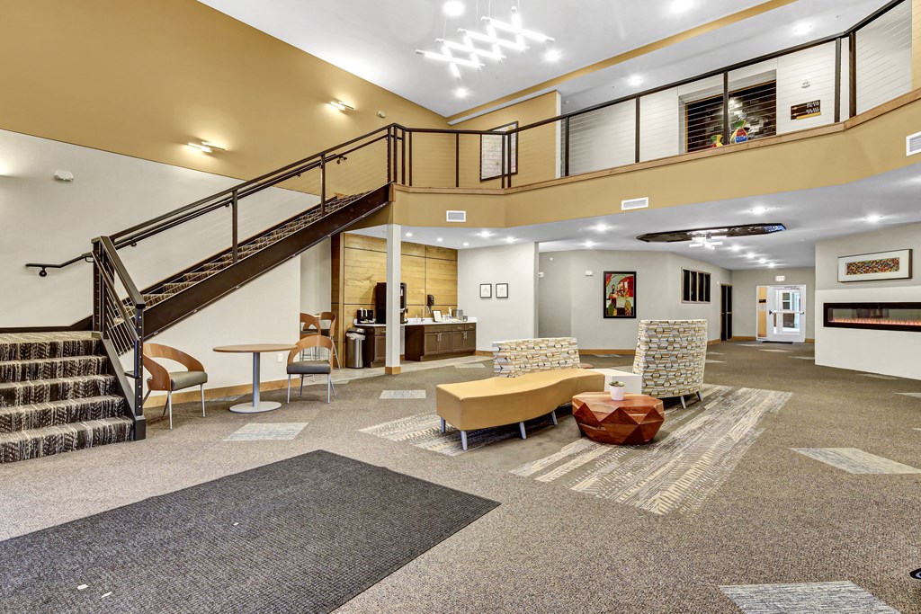 the lobby of a building with a staircase and couches