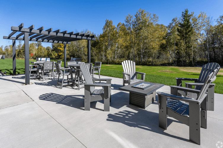 A patio with a table, chairs and a pergola.