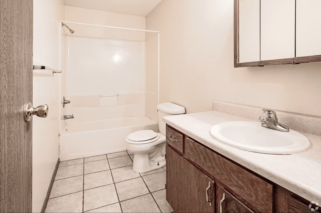 A bathroom with a toilet, sink, and shower.