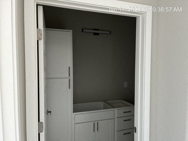 a bathroom with a sink and white cabinets