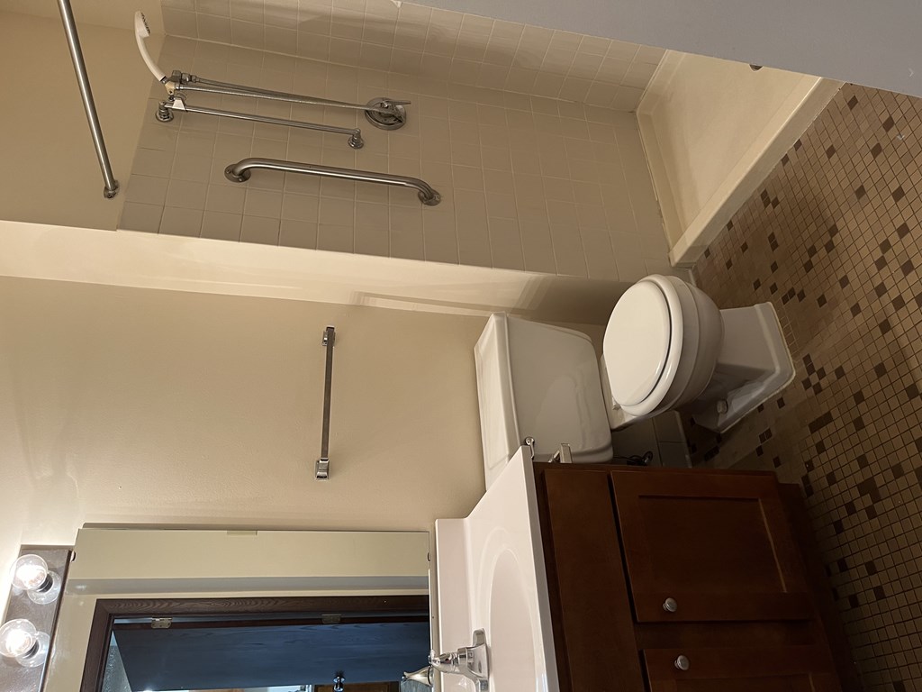 a bathroom with a toilet and a sink and a mirror