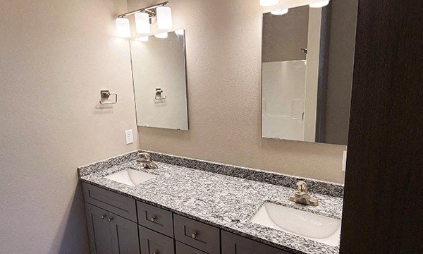 a bathroom with two sinks and two mirrors