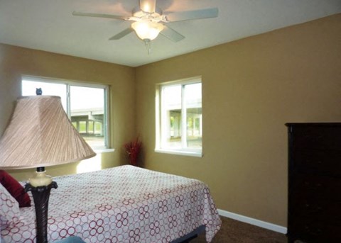 a bedroom with a bed and a ceiling fan