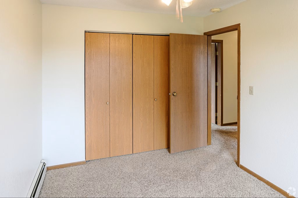 A room with a white wall and a brown door.
