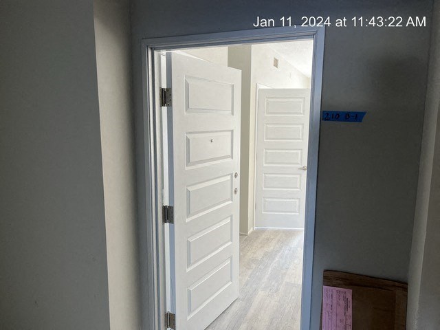an open door leading to a hallway with white doors