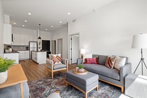 A modern living room with a grey couch and a wooden coffee table.