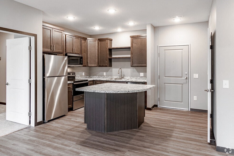 a kitchen with stainless steel appliances and a marble counter top