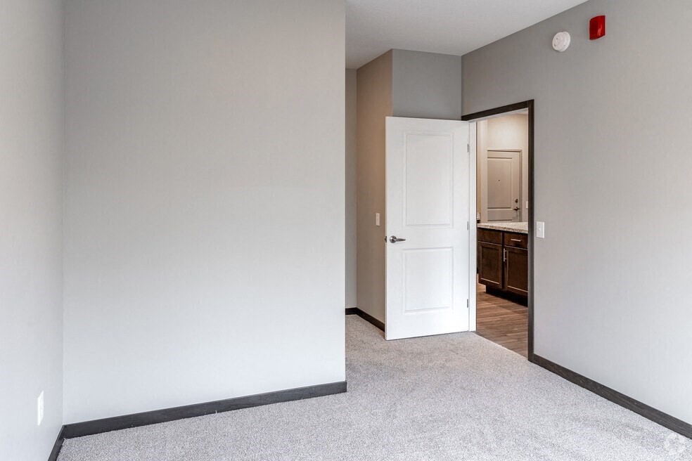 an empty bedroom with a door open to a bathroom