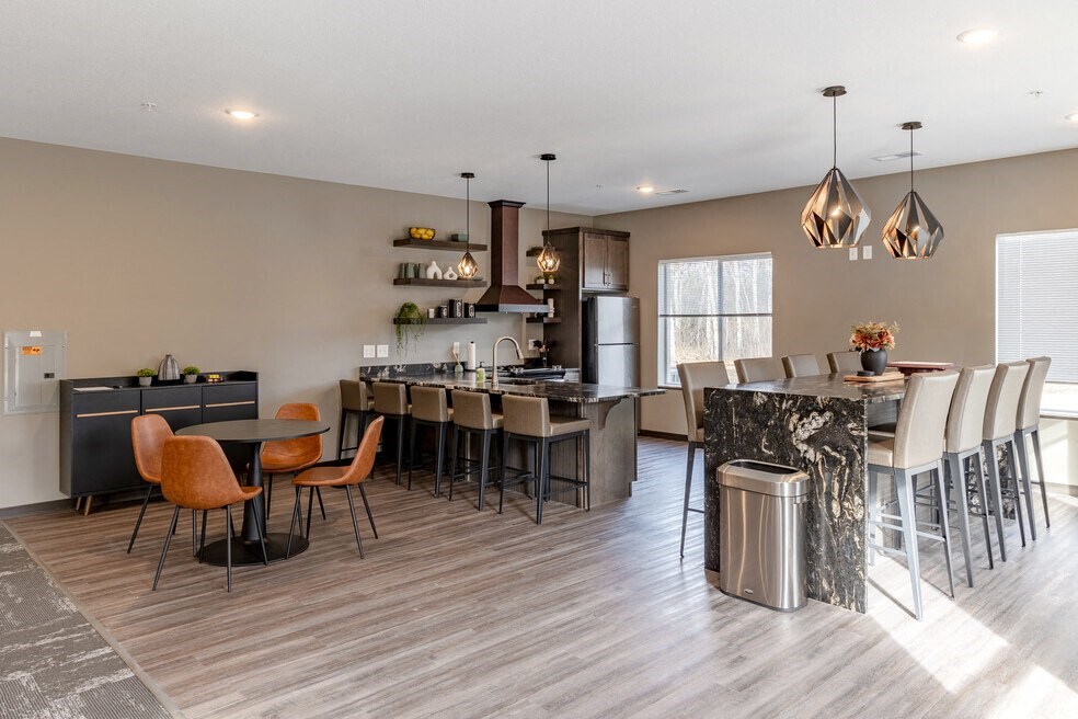 a kitchen with a bar and a dining room with chairs