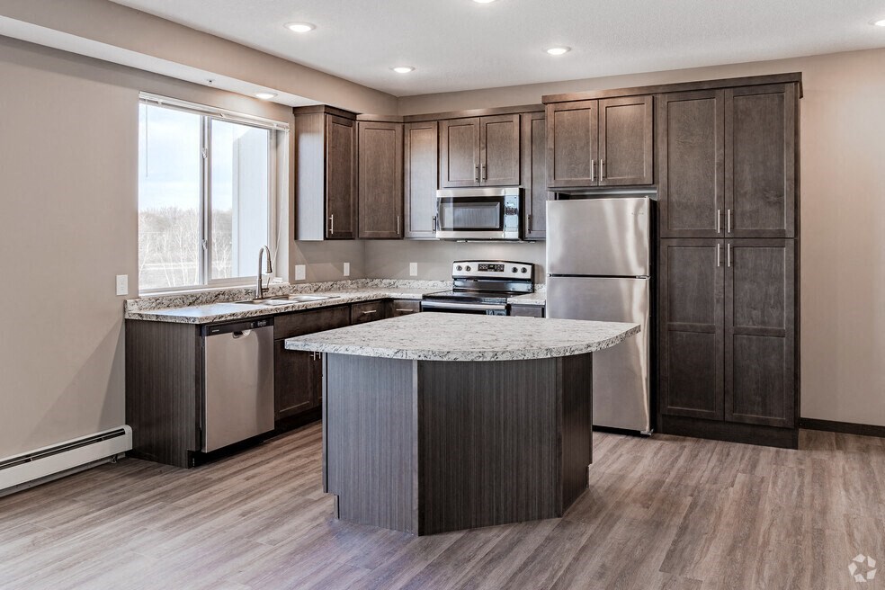 a kitchen with stainless steel appliances and a marble counter top
