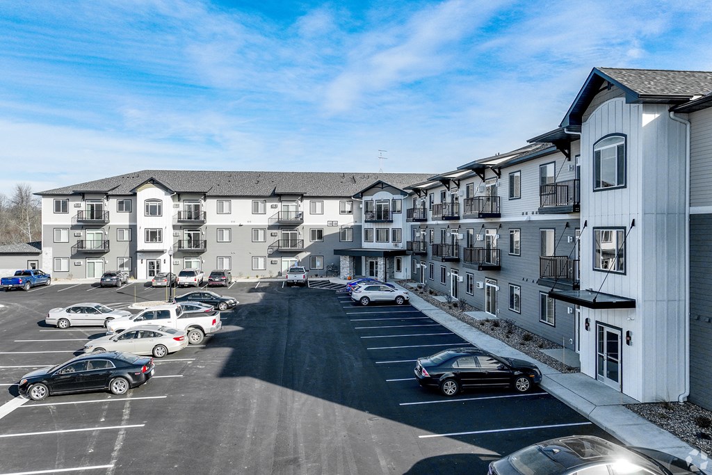 an aerial view of a parking lot in front of apartment buildings