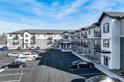 an aerial view of a parking lot in front of apartment buildings