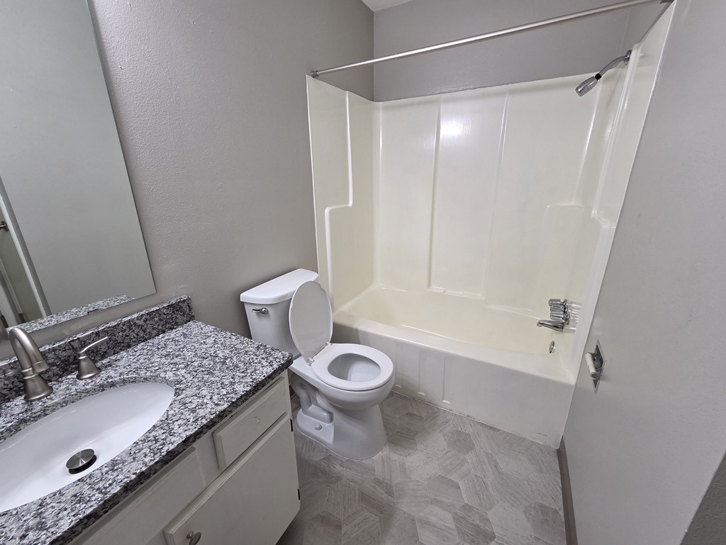 A bathroom with a toilet, sink, and bathtub.
