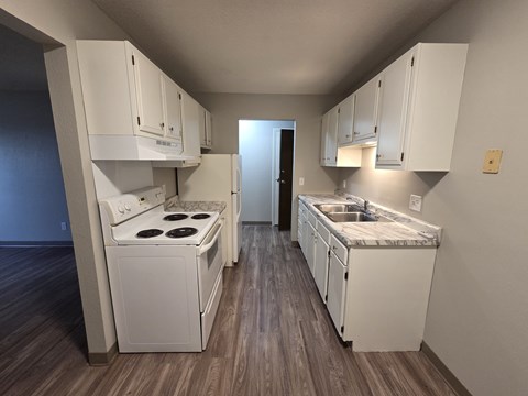 A kitchen with white cabinets and a stove top oven.
