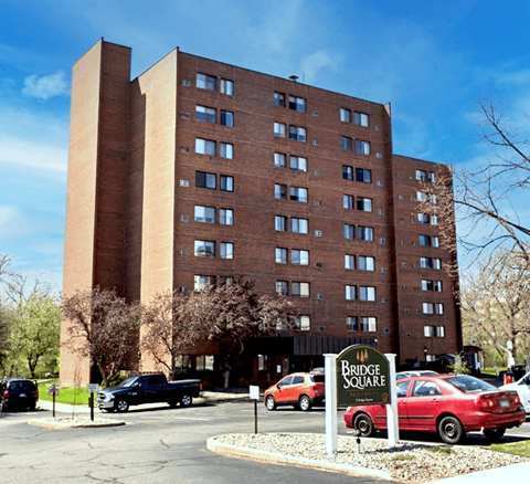 A large brick building with a sign that says Bridge Square in front of it.