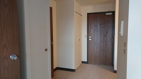 A hallway with a brown door and a white door.