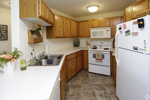 A kitchen with a white fridge and white oven.