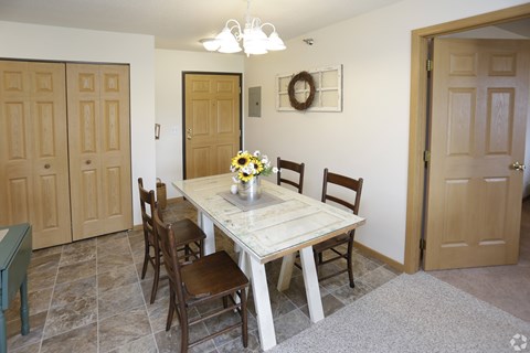 A dining room with a table and chairs.