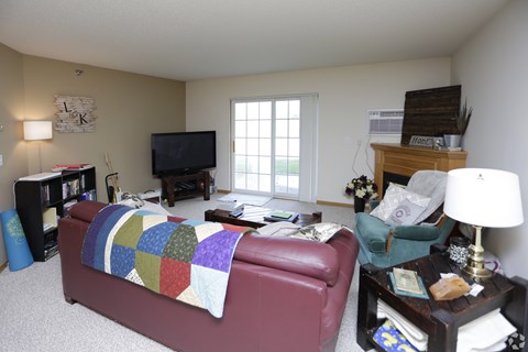 A living room with a red couch and a television.