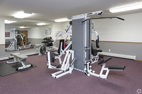 A gym with a variety of equipment including a leg press machine.