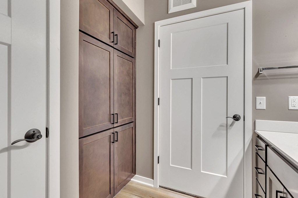 A white door is on the right and a brown cabinet is on the left.